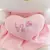 Pelúcia Hello Kitty segurando coração rosa com bordado da palavra "LOVE" e asas brancas