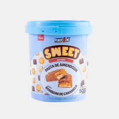 Fundo Cinza Claro com um pote de pasta de amendoim de 500g da marca Power One, pote com cor predominante sendo azul claro com letras em amarelo e vermelho. 