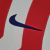 Camisa Titular Atlético de Madrid Nike 2022-2023 inspirada no rio Manzanares, com listras vermelhas e brancas, escudo Atleti no lado esquerdo e Swoosh Nike azul royal no lado direito.