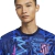 Terceira Camisa do Atlético de Madrid 2024/2025: azul marinho com grafismo vibrante. Destaques incluem o tridente de Netuno, Nike Swoosh rosa e escudo do Atleti em azul e rosa.