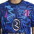 Terceira Camisa do Atlético de Madrid 2024/2025: azul marinho com grafismo vibrante. Destaques incluem o tridente de Netuno, Nike Swoosh rosa e escudo do Atleti em azul e rosa.