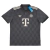 Camisa do Bayern de Munique para a Oktoberfest 2024. A peça apresenta um design inspirado no Trachten, com base cinza, padrão de diamantes, gola polo e detalhes em verde e off-white.