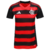 Camisa Flamengo I 2025/26 Feminina Adidas, listrada em vermelho e preto, gola V preta com friso vermelho, ombros pretos com três listras vermelhas da Adidas, escudo CRF branco no peito, logo Adidas branco, numeração e patrocínios em branco nas costas, des