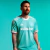 A terceira camisa do Inter Miami Adidas 2024 apresenta um design vibrante em azul celeste com linhas verticais, gola redonda branca e detalhes em laranja. O escudo do clube e o antigo logo da MLS em branco completam o visual inspirado nos anos 80