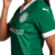 Camisa Palmeiras I 2025 Feminina, cor verde e branca, com gola V retrô branca, estampa especial das taças conquistadas pelo clube e as 12 estrelas dos títulos brasileiros. O escudo oficial do Palmeiras está no lado esquerdo do peito, com os logos da PUMA 