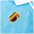 Camisa Reserva da Seleção Belga 2024/25 Adidas Azul celeste e branca. A camisa é predominantemente azul celeste com gola pólo branca, listras brancas nas mangas e detalhes em dourado. O escudo da Federação Belga de Futebol está presente no lado esquerdo d