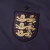 Camisa reserva da seleção inglesa Nike 2024-2025. Predominantemente na cor roxa vibrante, resultado da mistura inovadora de azul e vermelho, simbolizando a paixão e a ousadia da seleção inglesa. O escudo da seleção e o logo da Nike no peito são dourados, 