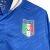 Camisa titular retrô da Seleção Italiana Puma 2012-2013, usada na Euro 2012. Design azul e branco com detalhes em branco. A camisa apresenta o logo da Puma e o escudo da Federação Italiana de Futebol. Andrea Pirlo, o maestro da equipe, é visto usando esta