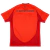 camisa titular do Bayern de Munique para a temporada 2024-2025. A camisa apresenta três tons de vermelho, com faixas verticais estilizadas em um tom mais escuro formadas por retículas de diamantes. A gola V e a parte frontal seguem o design do kit, enquan