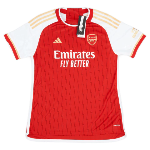 Camisa Titular Feminina do Arsenal Adidas 2023/24 em vermelho, branco e dourado. Detalhes como raios dourados na nuca, faixas laterais com 26 vitórias e 12 empates de 2003-2004, dorsais brancas e gola redonda vermelha com contorno dourado. As três listras