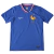 Camisa titular da seleção francesa de futebol 2024-2025. Camisa na cor azul royal com gola V tricolor e o galo, símbolo da seleção, em tamanho maior que o convencional. Na parte interna da gola, a frase "Nos différences nous unissent" (Nossas diferenças n