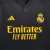 Terceira Camisa Real Madrid Adidas 2023/24 Masculina em preto, amarelo e cinza, destacando as três listras cinzas nas mangas, gola redonda com abertura de um botão e escudo amarelo vazado no peito. Logo Adidas e patrocínio Emirates em amarelo.