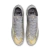 Chuteira Nike Mercurial Superfly 9 Elite XXV SE FG na cor Prata Metálico/Preto/Cinza Lobo. A chuteira possui um design de edição limitada com a marca "MXXV" e detalhes em azul e dourado que remetem ao Mercurial R9 original de 1998. A parte superior e a so