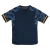 conjunto infantil reserva do Real Madrid Adidas 2023-2024. A camisa é azul marinho com um design de ondas em tom mais claro. A gola é redonda e há detalhes em azul marinho nas laterais e na barra. As três listras nos ombros são amarelas, brancas e roxas.
