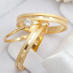 Par de alianças banhadas a ouro 18k com acabamento brilhante, exibindo um design elegante e moderno.