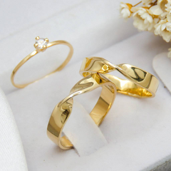 Par de alianças banhadas a ouro 18k com acabamento brilhante, exibindo um design elegante e moderno.