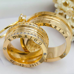 Par de alianças banhadas a ouro 18k com acabamento brilhante, exibindo um design elegante e moderno.