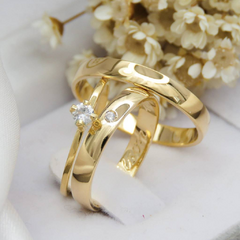 Par de alianças banhadas a ouro 18k com detalhes em pedras brilhantes.