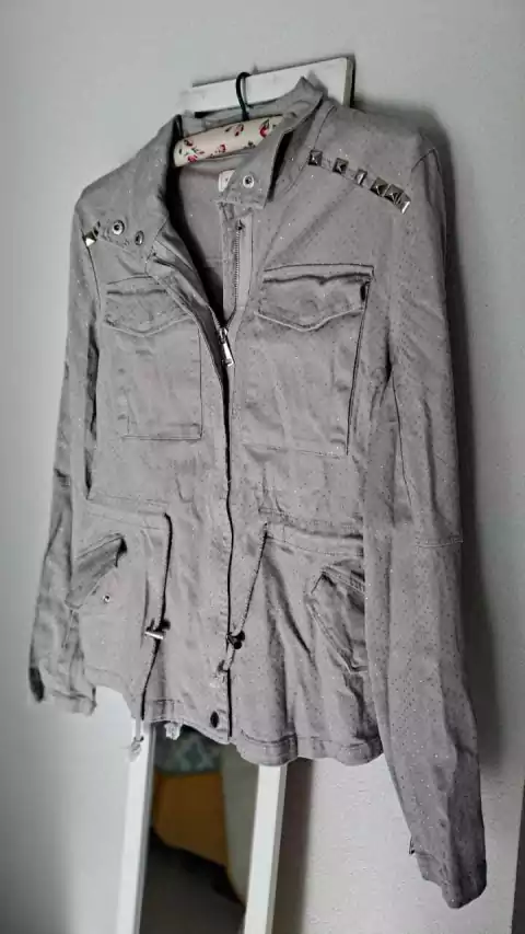 Chaqueta gris c/brillo, tachas y cierres. MOTIVI. Talle S