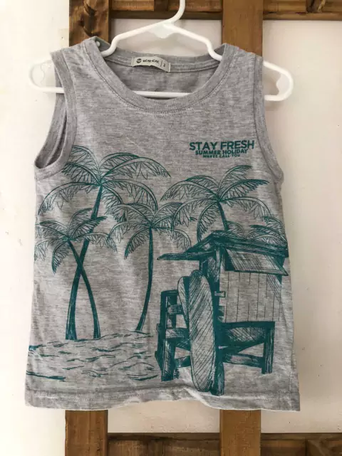 Remera musculosa gris con estampa de palmeras. Weak Meak. Talle 2 años.