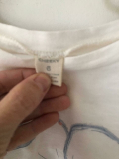 Remera blanca con flor azul. CHEEKY. Talle 6 años. en internet
