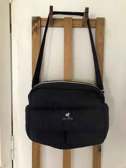 Bolso maternal azul forrado adentro.