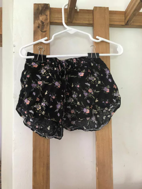 12M | Short finito negro con flores y elástico. URB. 12 meses.