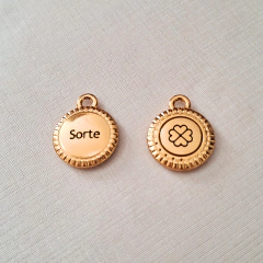 Medalha dourada com a inscrição "Sorte" de um lado e um símbolo de sorte do outro lado.