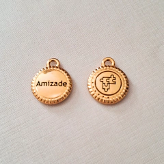 Medalha dourada com os dizeres "Amizade" e um símbolo em relevo, parte da Pulseira Turmalina Negra.