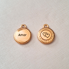 Medalha de ouro com a palavra "Amor" em uma face e um desenho de corações na outra.