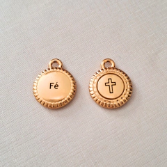 Pendentes dourados com as palavras "Fé" e uma cruz, representando espiritualidade.