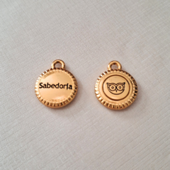Medalha dourada com a palavra 'Sabedoria' em uma face e o desenho de uma coruja na outra.