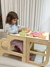 niña usando la torre desplegada, como mesa y banco