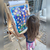niña jugando en atril de madera con panel de juego