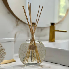 Difusor Jardim Sensorial em gel com varetas e glitter dourado em cima d euma bancada de banheiro