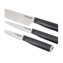 Jogo de três facas KitchenAid em aço japonês com cabos pretos, incluindo uma faca de chef, uma faca de utilidade e uma faca para descascar.