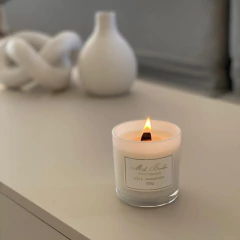 Vela aromática de cereja e avelã da Mels Brushes acesa sobre uma mesa decorativa.