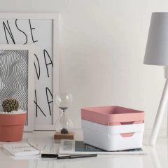 mesa com revistas, abajur, quadros, plantas e caixas organizadoras em cima