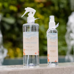 Frascos de água para tecidos da linha Pacific House, um de 500ml e outro de 200ml, em um ambiente natural com fundo verde.