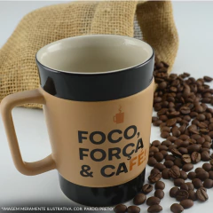 caneca borda preta com uma faixa ocre e escitra ao lado de grãos de café