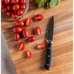 faca de nove centímetros posicionada em cima da tábua de madeira ao lado de tomates cortados e inteiros