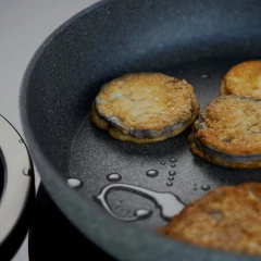 Frigideira antiaderente Salina Granitium de 20cm com fatias de berinjela fritas.