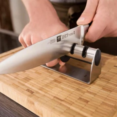 homem afiando a faca em um afiador aço inox