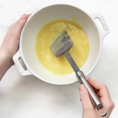 mulher mexendo uma mistura com uma espátula