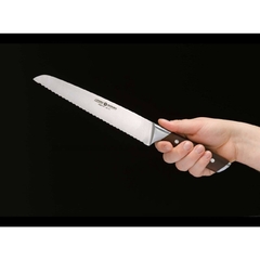 Pessoa segurando uma faca para cortar pães com lâmina de aço inox e cabo de madeira da marca böker