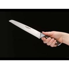 Pessoa segurando uma faca para cortar pães com lâmina de aço inox e cabo de madeira da marca böker
