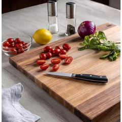 faca de nove centímetros posicionada em cima da tábua de madeira ao lado de tomates, cebola e limão