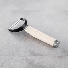 Descascador de legumes e frutas KitchenAid, com cabo creme e lâmina preta.