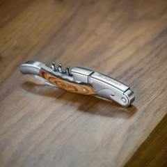 um Saca-Rolhas Mini, modelo Roero com acabamento de Madeira Faia  e aço inox da marca italiana Legnoart em cima de uma mesa