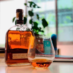 copo redondo do lado de uma garrafa de whisky